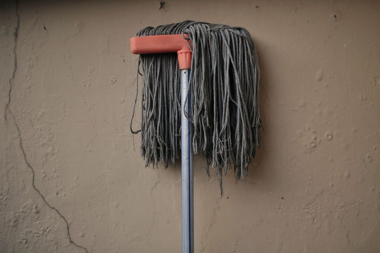 services-01 Gray mop leaning against a textured wall, conveying simplicity in a domestic setting.